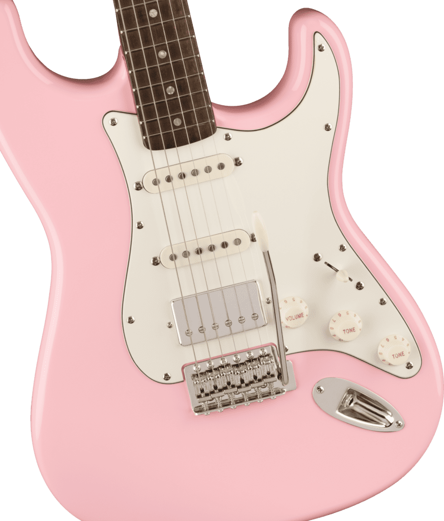Squier FSR Classic Vibe 60's Stratocaster Electric Guitar in Shell Pink. Close-up of body with 3 control knobs on 6-string guitar