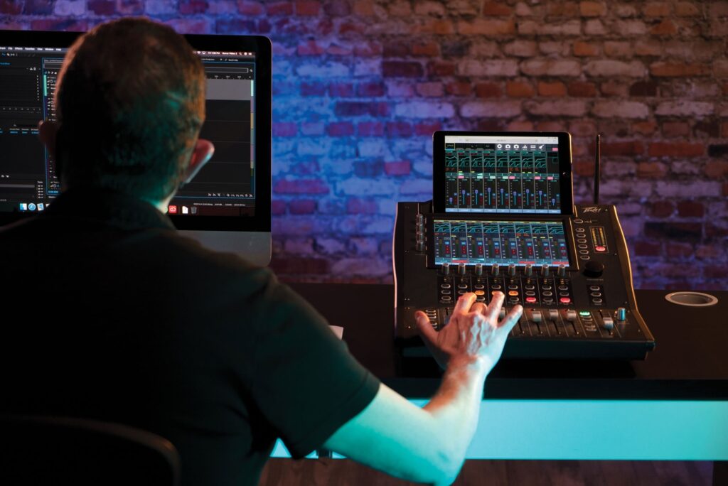 Male sound engineer controlling Peavey Aureus 28 Digital Mixer in studio